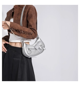 Modèle portant un sac hobo Y2K argent métallisé avec boucles punk et poches multiples