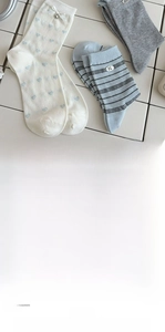 Detail of sweet mid-calf cotton socks with heart floral patterns and metallic charms