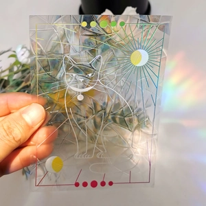Rainbow holographic window film with sun, moon, and cat design catching vibrant sunlight