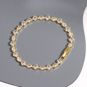 Detailed view of square-cut zircon tennis bracelet with gold plating and secure fold-over clasp