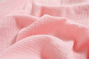 Close-up of soft pink cotton waffle fabric texture with natural breathable folds