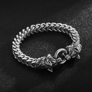 Detailed view of matte silver wolf head buckle and heavy steel chain on men's bracelet