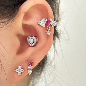 Titanium steel heart and star earrings set with pink stones shown on ear model