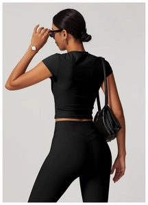 Rear view of black slim-fit cropped yoga top and high-waist leggings with elastic fabric