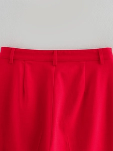 Gros plan détaillé de la taille d'un pantalon rouge avec passants et plis du tissu