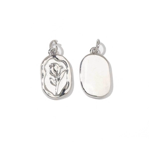 Close-up of silver oval charms with rose relief and smooth back on white background