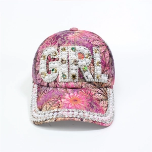 Detailed close-up of GIRL letter pearl and rhinestone embroidery on pink floral cap