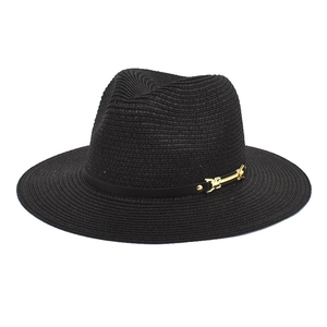Detail of black straw fedora hat featuring a gold buckle on the decorative band