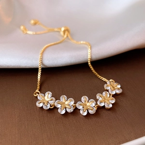 Detail of gold-plated star flower bracelet with zircon stones on silk and velvet