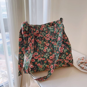 Close-up of green floral canvas tote bag with textured cotton fabric and floral wide strap