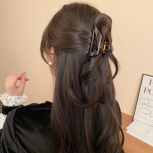 Detailed back view of a large brown triangle hair claw clip in a half-up hairstyle