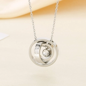 Close-up of silver triple ring pendant with zircon and I love you engraving
