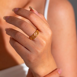 Close-up of a 18K gold-plated stainless steel hollow geometric ring on a finger