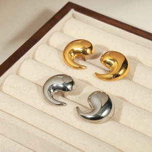 Minimalist geometric teardrop gold and silver stud earrings in a wooden jewelry box