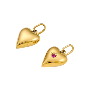 Close-up of golden heart pendants with pink zircon stones in a high-polished finish