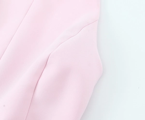 Macro detail of pink knit fabric showing textured weave and high-quality seam stitching