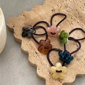 6-piece set of acrylic jelly flower hair ties in diverse colors on stone background