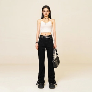 Women's mid-wash high-stretch flared jeans paired with white crop top and studded accessories
