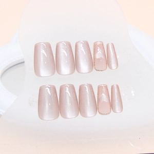 Pink cat-eye press-on nails with silver heart pattern and glittery gold accents