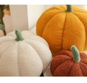 Detailed close-up of pumpkin plush pillows in teddy fleece fabric and soft warm colors
