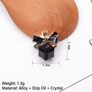 Macro detail of a black enamel bow pendant with a crystal drop, size 1.4cm x 1.2cm