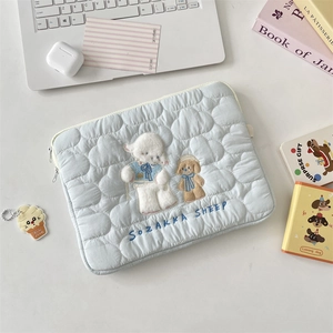 Detalle de la funda acolchada azul claro con bordado de oveja y cremallera doble para PC