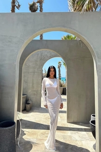 Détail d'une robe de plage blanche en maille transparente avec des manches longues et amples