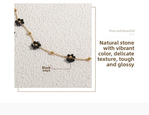 Detailed macro view of 18K gold daisy pendant with natural black agate and small beads