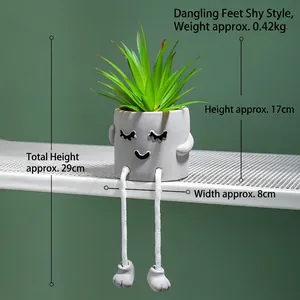 Creative hanging leg artificial succulent in a grey cylindrical cement pot with a cute face