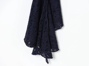 Detail shot of navy blue lace fabric with intricate floral hollow out embroidery pattern