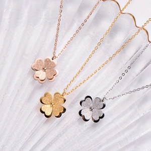 Detailed view of three frosted clover necklaces in rose gold, gold, and silver finishes