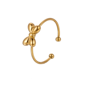 Close-up of golden bow-shaped open cuff bracelet featuring sleek minimalist metal texture