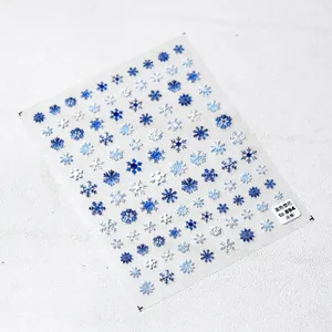 Macro detail of 5D embossed blue and white snowflake nail art stickers for winter decor
