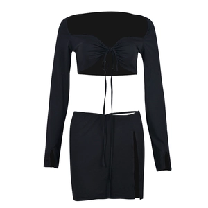 Detail of black two-piece set featuring lace-up crop top and side slit mini skirt