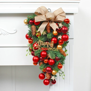 Christmas upside down hanging tree with red gold ornaments and burlap bow on fireplace