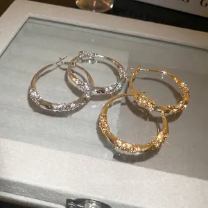 Twisted silver needle hoop earrings with pavé crystals in gold and silver finish