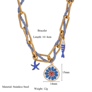Detail of stainless steel blue woven bracelet with starfish and fish enamel charms