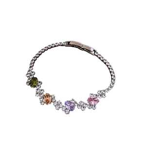 Elegant silver bracelet with zircon crystals and four colorful oval gemstones on white background