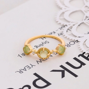 Detail of 925 silver gold-plated ring with green prehnite stones and white zircons