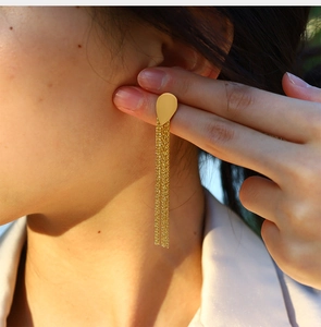 Detail showing high-shine 18K gold-plated teardrop earrings with elegant long tassels