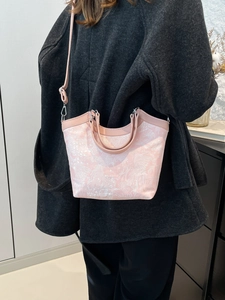 Pink jacquard shoulder bag with floral embroidery and leather trim shown in a lifestyle view