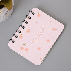 Close-up of pink A7 spiral notebook featuring cherry patterns and lovely Chinese text