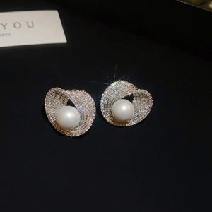 Macro view of sterling silver pearl earrings with sparkling zircon spiral halo