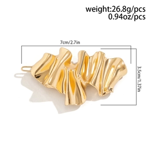 Detail view of irregular golden liquid metal hair clip with size 7cm by 3.5cm
