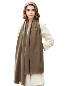 Detailed view of soft brown cashmere-feel scarf featuring delicate tassels on a model