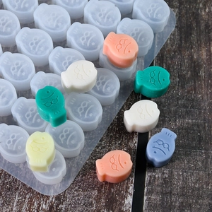 Vista detallada del molde de silicona con forma de pez con dulces y chocolates variados