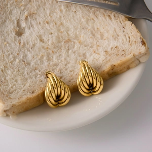 Macro d'oreilles goutte en plaqué or 18 carats avec rayures texturées sur pain blanc