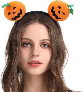 Detail of plush orange pumpkins with black faces on a Halloween headband accessory