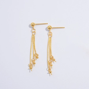 Detail of gold ball stud earrings with triple snake chain tassels and pearl mounting pins