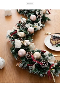 Christmas garland with pinecones and ornaments on a wooden table, holiday scene